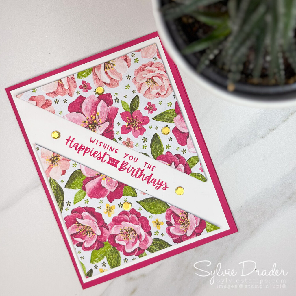 A simple card with triangles of pretty floral paper. The flowers on the paper (hues of happiness from Stampin' Up!) are in shades of pink. The greeting is stamped in Melon Mambo between the two triangles.